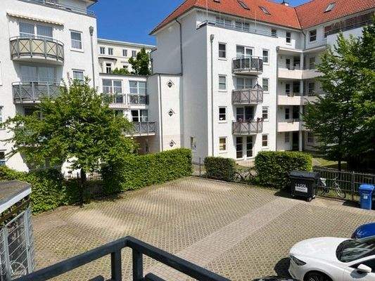 Blick vom Balkon in den Hof mit Parkplätzen