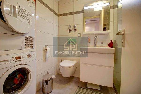 Bad mit großer Dusche und Waschmaschine