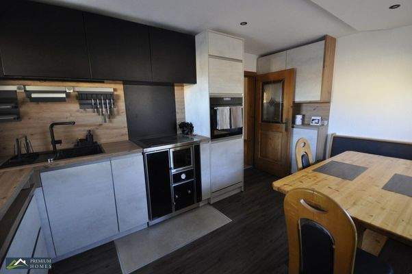 Moderne 3-Zimmer-Eigentumswohnung - Küchenansicht mit Esstisch und Zugangstür