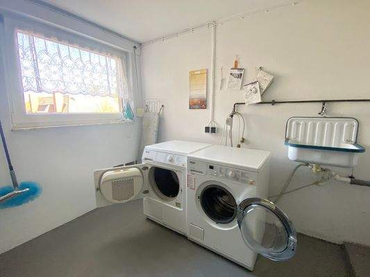 gemeinschaftlicher Hauswirtschaftsraum mit Waschmaschine, Wäschetrockner und Zentralheizung