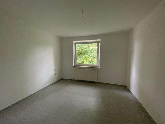 eines der drei Zimmer mit Fenster und Heizkörper.JPG