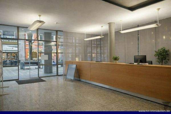 Heller, moderner Empfangsbereich mit Glasfront und Holztheke