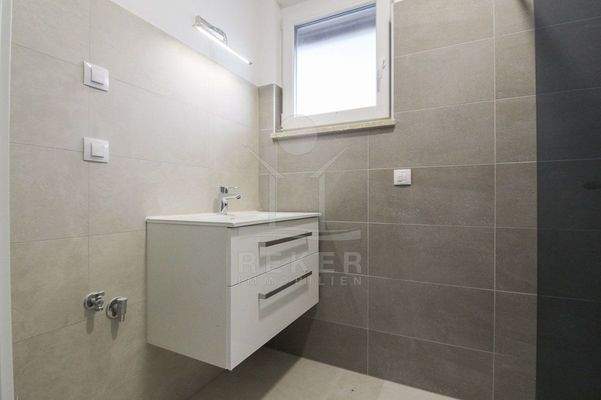 Bad mit modernen Fliesen und Tageslicht