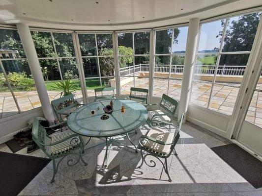 Heller Wintergarten mit Panoramablick auf die Terrasse und Garten