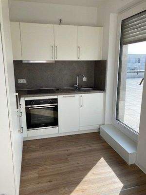 Einbauküche in weiß mit Zugang zur Loggia