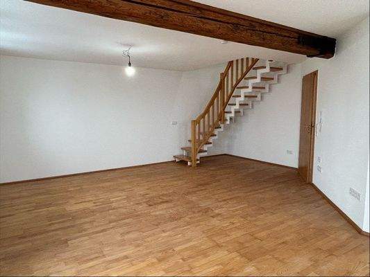 Wohnzimmer mit Treppe in die Dachspitze