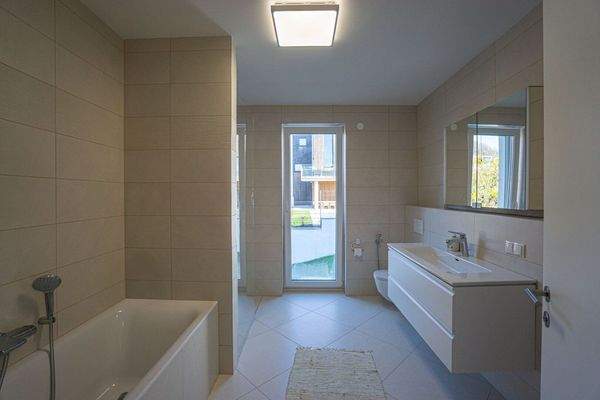 Badezimmer mit Wanne, bodengleicher Dusche, Waschtisch, Spiegelschrank und WC