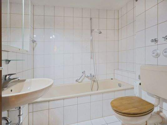 Hell gefliestes Badezimmer mit Wannendusche