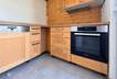 Aufgeräumte moderne Küche mit Holzfronten