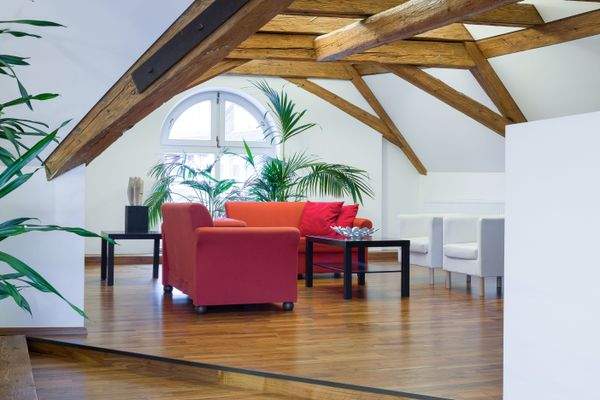 Stühle und Tische unter Dachboden mit Dachschräge