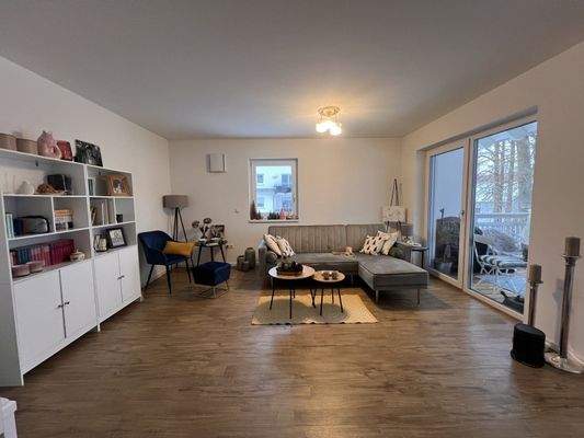 Lichtdurchflutetes Wohnzimmer mit großzügiger Raumaufteilung und Balkonzugang