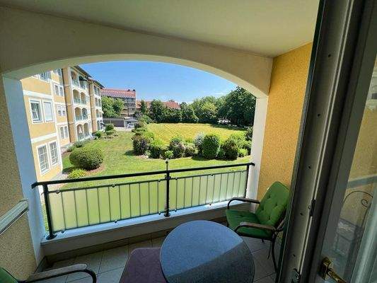 Gemütlicher Balkon mit Blick auf gepflegte Gartenanlage