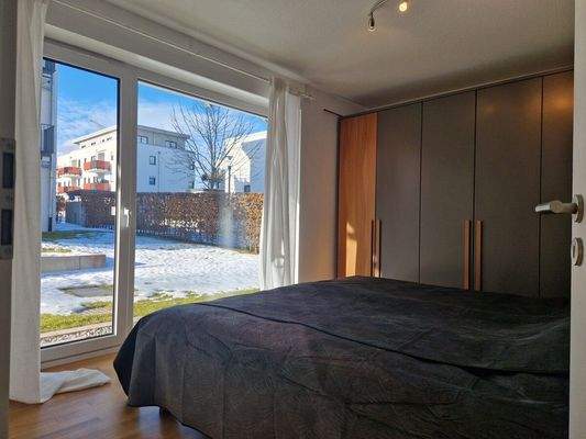 Schlafzimmer mit bodentiefem Fenster