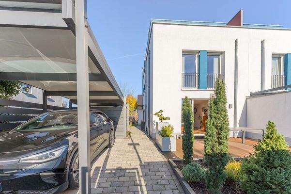 Blick vom Tor auf das Haus, die Terrasse und das Carport