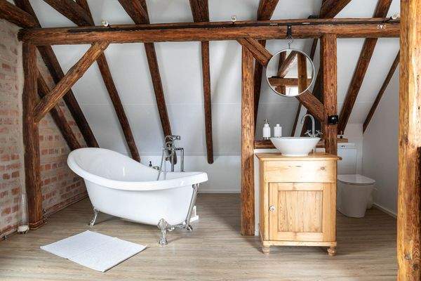 Freistehende Badewanne vor Ziegelwand