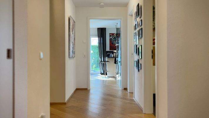 Durch die Glastüre zwischen Flur und Wohnzimmer ist auch dieser Bereich lichtdurchflutet