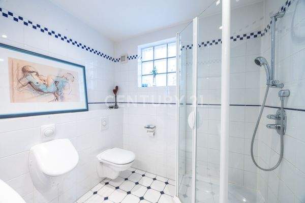 Hell gefliestes Gäste WC mit Dusche