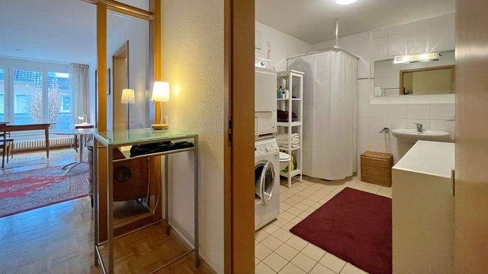 Blick vom Eingangsbereich ins helle Wohn- und Esszimmer sowie in das Badezimmer 