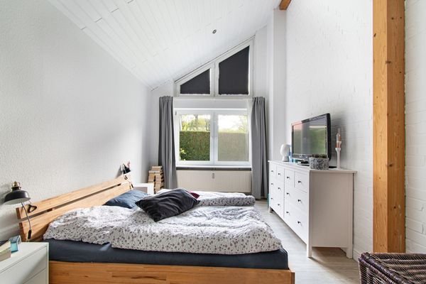 Ruhiges Schlafzimmer mit Blick ins Grüne und hohen Decken