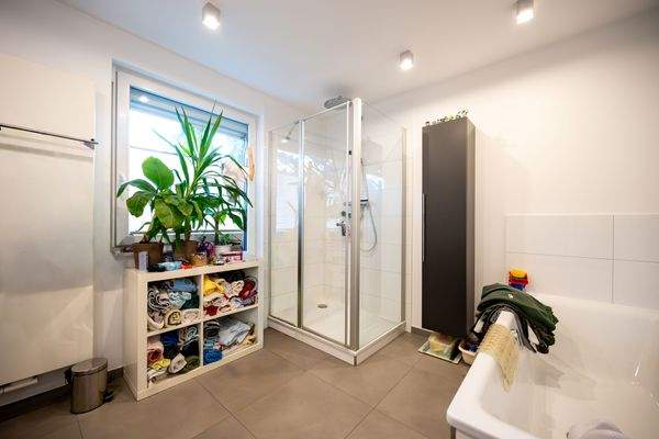 Helles Badezimmer mit Dusche und Badewanne im OG