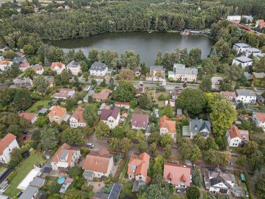 Luftaufnahme: Haus in idyllischer Lage mit See in der Umgebung