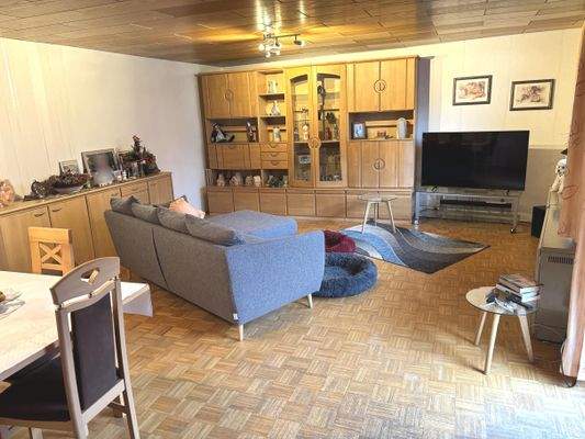 helles Wohn- und Esszimmer mit Parkettboden und Balkonzugang im Obergeschoss