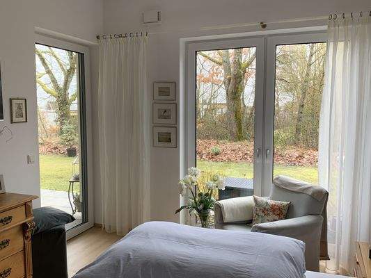 Schlafzimmer mit Blick in den Garten und Zugang zur Terrasse