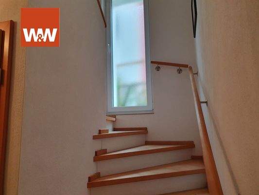 Massivtreppe mit Holztrittstufen und Rundholzhandlauf zum OG