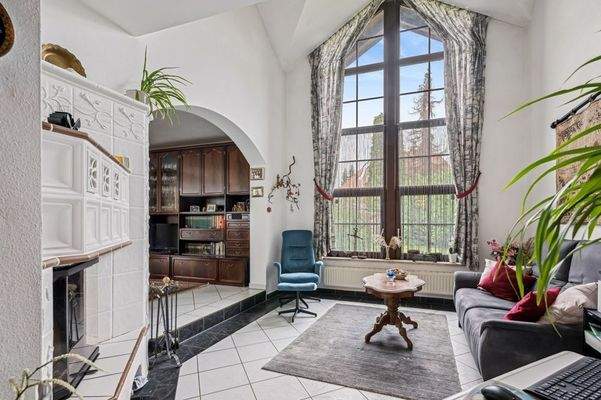 Kaminzimmer mit deckenhohem Fenster im EG