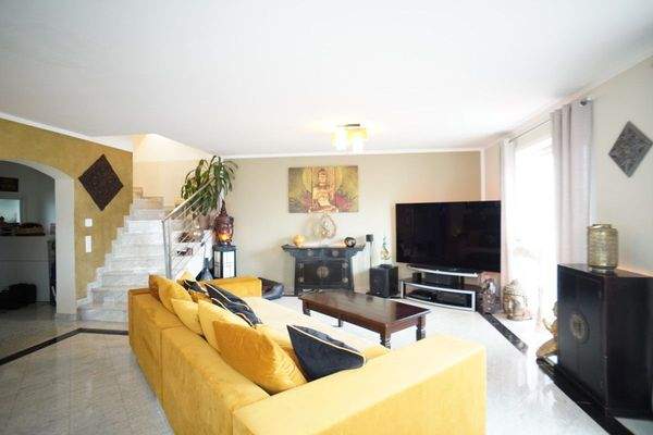 Wohnzimmer mit Treppen zum zweiten Stockwerk