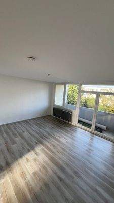 Wohnzimmer mit Fenster, Heizung und Balkon