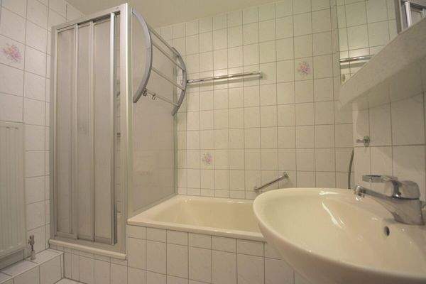 Badezimmer mit Wanne, Dusche und Waschmaschinenanschluss