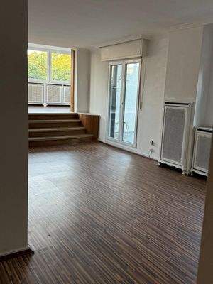 Lichtdurchfluteter Wohnbereich mit eleganter Ebenengestaltung und großzügiger Fensterfront