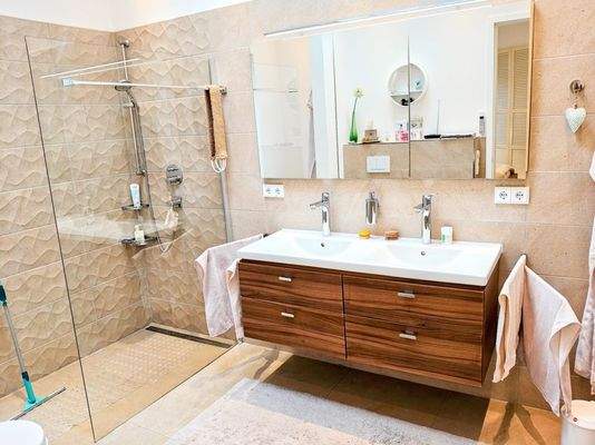 Badezimmer mit bodengleicher Dusche und Wanne