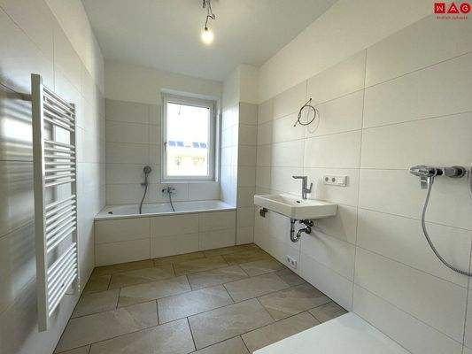 Badezimmer mit Badewanne, Dusche und Fenster