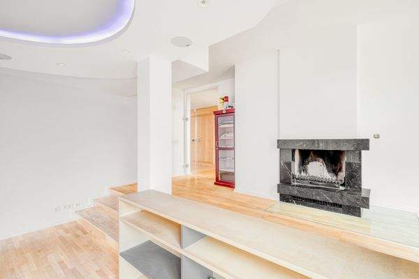 Großzügiger Wohnsalon mit Natursteinkamin und integrierter  Lichtvoutenbeleuchtung