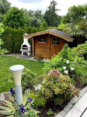 Blick auf das Gartenhaus und den Grill