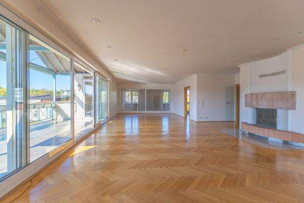 Großes Wohnzimmer mit Kamin und Zugang zum großen, 
überdachten Balkon