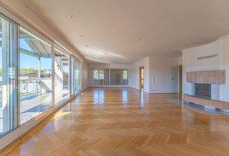 Großes Wohnzimmer mit Kamin und Zugang zum großen, 
überdachten Balkon