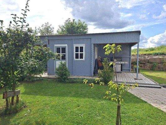 Gartenhaus mit überdachtem Grillplatz.