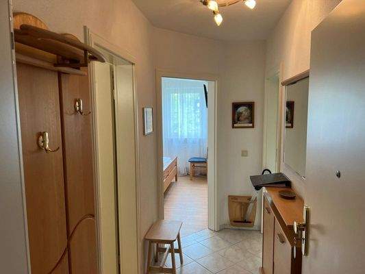 Heller Eingangsbereich mit praktischem Stauraum und Blick ins Schlafzimmer