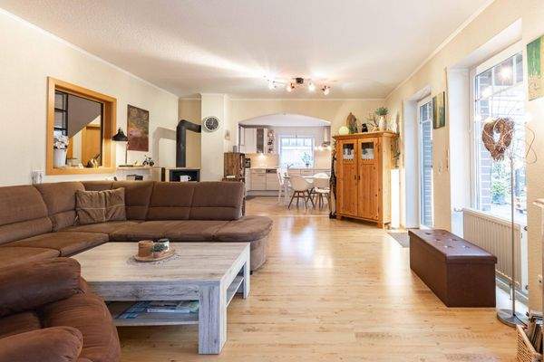 Lichtdurchfluteter Wohnbereich mit Kaminofen und Zugang zur überdachten Terrasse