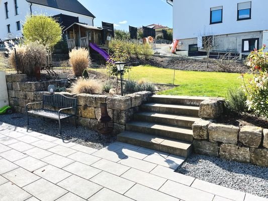 Blick ins Grüne... die mit Natursteinen eingefriedete Terrasse