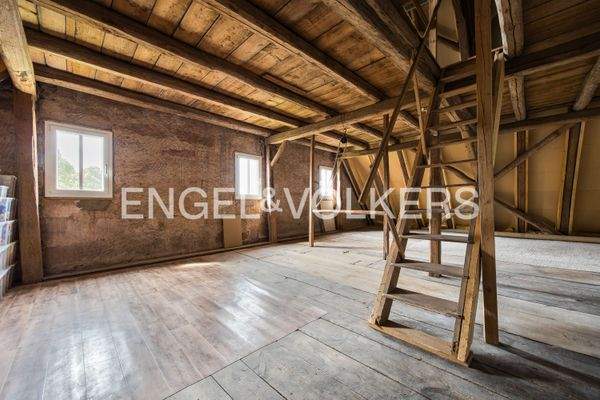 Unausgebauter, heller Raum im Obergeschoss mit Treppe in das Dachgeschoss