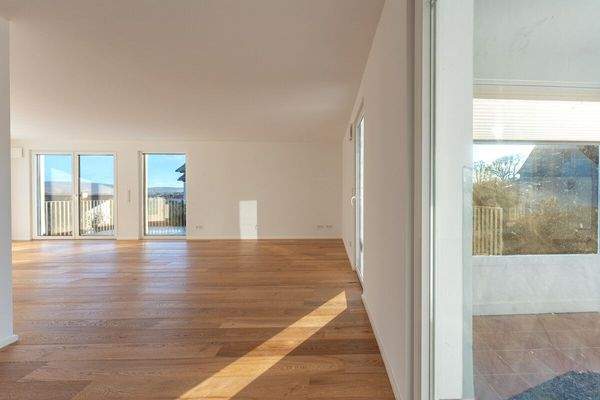 Blick aus der Küche in den Wohnbereich mit Zugang zum Wintergarten und Balkon