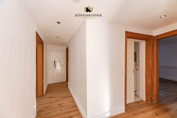 Einladender Eingangsbereich – warme Holzoptik und klare Linien führen in die charmanten Wohnräume