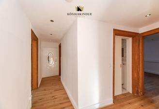 Einladender Eingangsbereich – warme Holzoptik und klare Linien führen in die charmanten Wohnräume