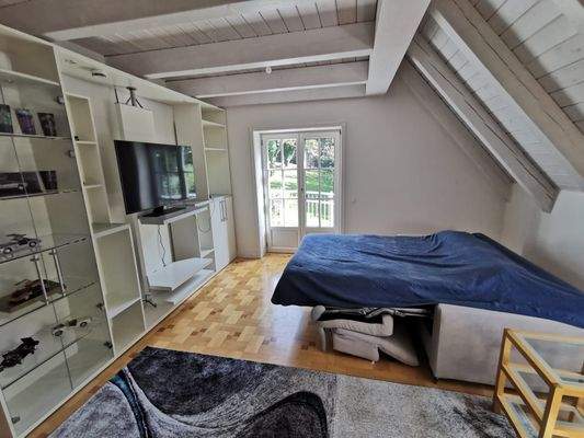 OG: Zimmer Kind 2 mit Einbauregal, Schlafsofa und Balkonzugang