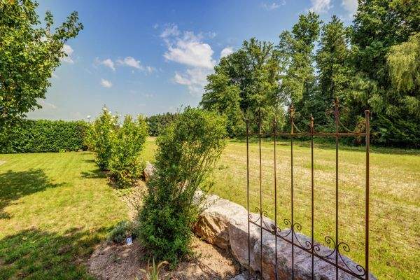 offen gestaltete Grundstücksmauer zum Feld und Wald