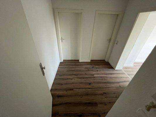 Weisser Flur mit Holzboden